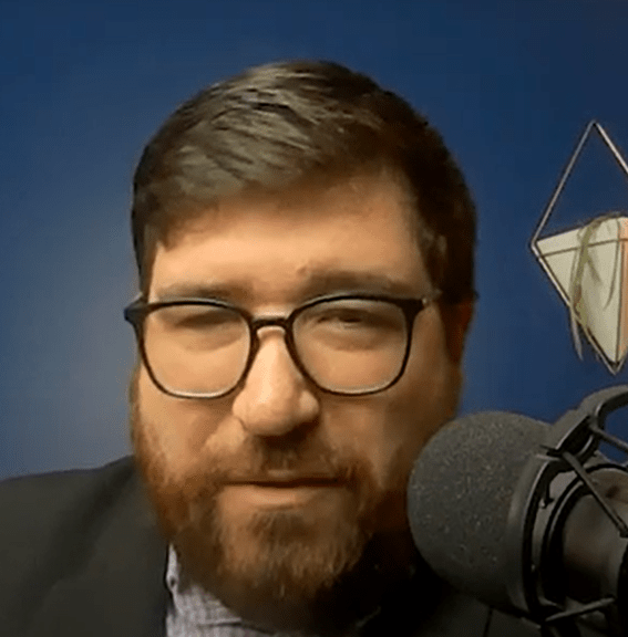 Jesse Preston sits behind a large microphone.