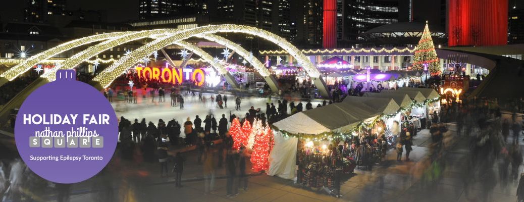 Nathan Phillips Square skating rink, Toronto Sign, white vendor tents, holiday decor and shoppers.